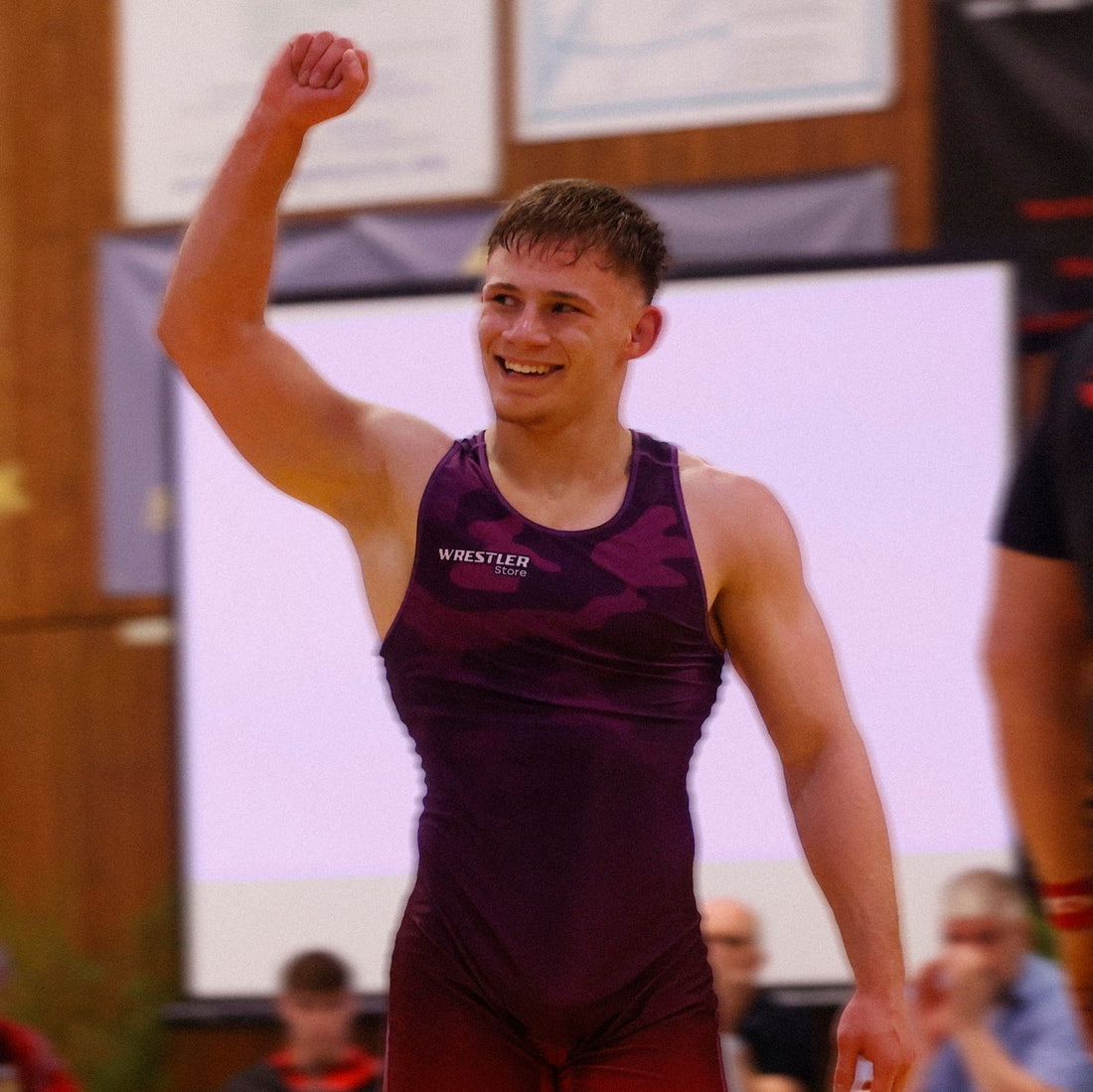 Junger Ringer im lila WrestlerStore Ringertrikot hebt nach einem Sieg die Faust – Titelbild zum Guide über Ringen Gewichtsklassen 2026
