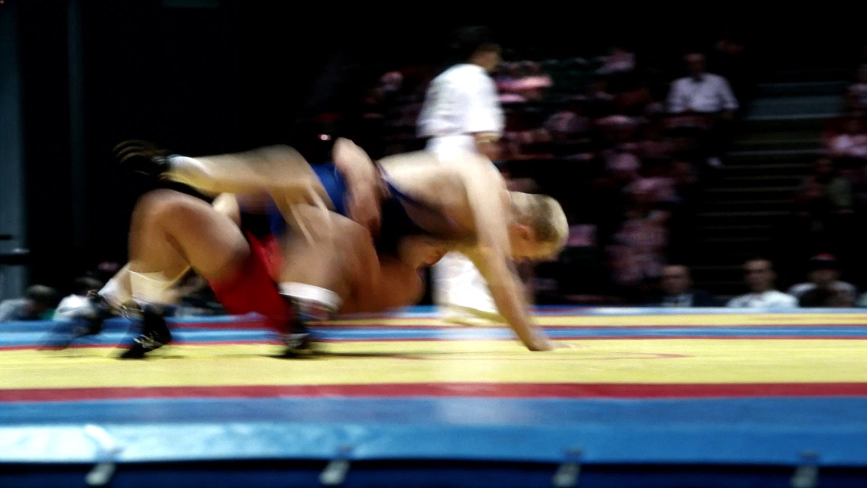 zwei Ringer im Wettkampf bei einem dynamischen Takedown auf der Matte – Ringersport Action