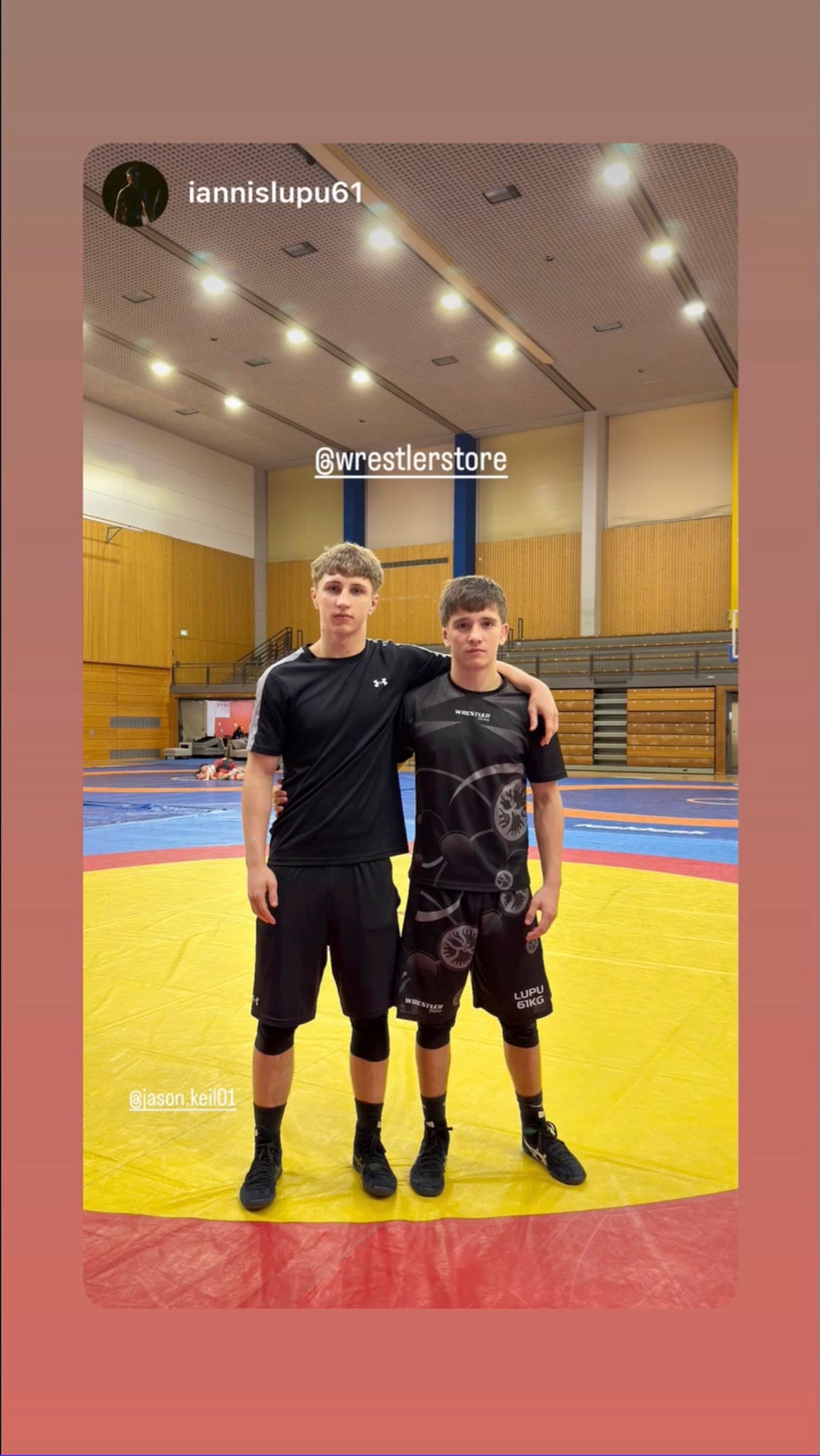 Zwei Ringer in WrestlerStore Trainingskleidung auf der Ringermatte im Trainingscamp