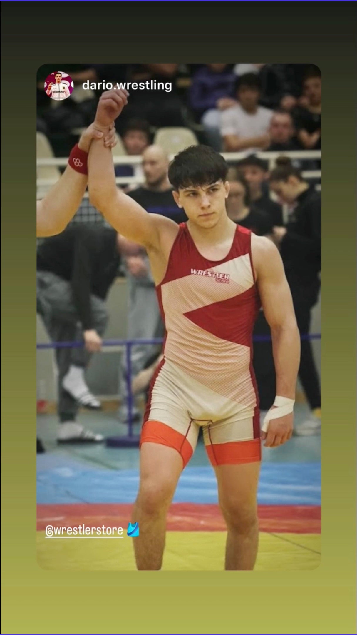 Ringer feiert Sieg im rot-weißen WrestlerStore Trikot beim Wettkampf – Arm wird gehoben